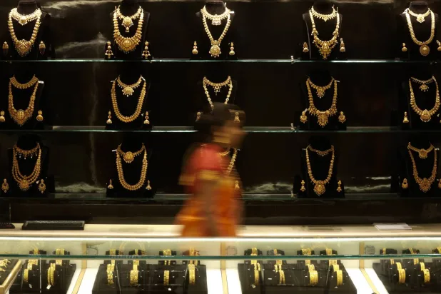 An image taken with a slow shutter speed showing an Indian woman walking in front of gold ornaments at a jewelry shop on the occasion of the Akshaya Tritiya festivities in Bangalore, India, 20 April 2026. (EPA)