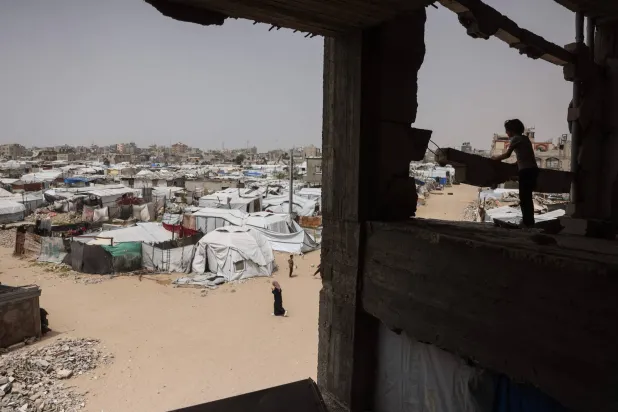 A child stands in a destroyed building overlooking makeshift shelters for displaced Palestinians in Khan Yunis in the southern Gaza Strip on April 18, 2026. (AFP)