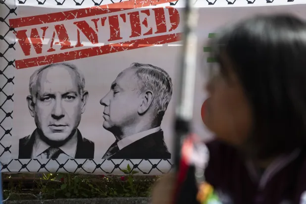 لافتة تحمل صورة لرئيس الوزراء الإسرائيلي بنيامين نتنياهو خلال احتجاجات على الضربات الأميركية الإسرائيلية على إيران في سيول (إ.ب.أ) 