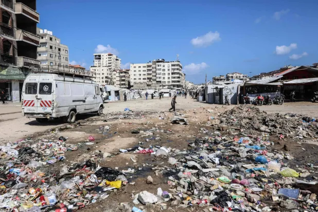 Garbage litters the ground next to makeshift shelters housing displaced Palestinians in Gaza City on April 20, 2026. (AFP)