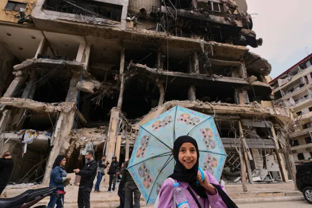 طفلة أمام مبنى تعرَّض لغارات إسرائيلية في الضاحية الجنوبية لبيروت (أ.ب)