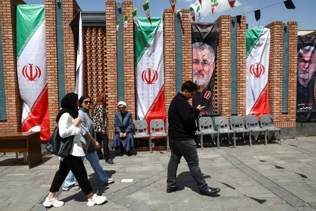 People walk past a banner with a picture of the late Iranian Revolutionary Guard Corps (IRGC) commander Mohammad Pakpour, in Tehran Bazaar, amid a ceasefire between US and Iran, in Tehran, Iran, April 21, 2026. Majid Asgaripour/WANA (West Asia News Agency) via Reuters
