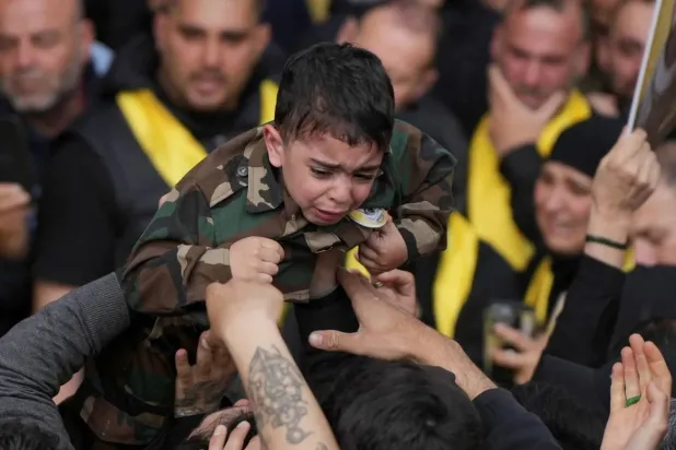 A child wearing a military uniform at the funeral of a Hezbollah fighter in Beirut’s southern suburbs during the truce with Israel (Reuters)