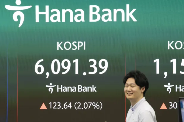 متداول كوري جنوبي يعمل أمام شاشة بيانات مالية ببنك هانا في سيول (إ.ب.أ)