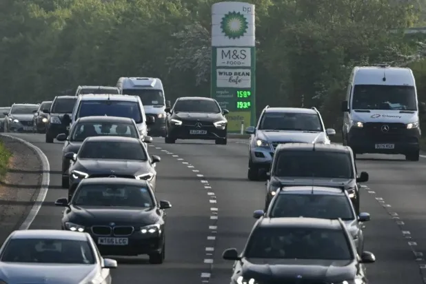 Vehicles pass a petrol station as they make their way down the A3 during the morning rush hour near Ripley, south-west of London on April 22, 2026. (AFP)