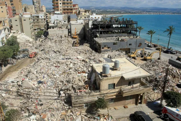 Diggers remove the rubble of buildings destroyed in Israeli strikes as they look for survivors buried underneath in the southern Lebanese coastal city of Tyre on April 21, 2026. (Photo by Mahmoud ZAYYAT / AFP)