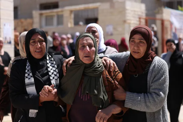 أقارب المراهق الفلسطيني أوس حمدي النعسان يشاركون في جنازته شرق مدينة رام الله في الضفة الغربية (إ.ب.أ)