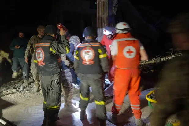 This photo released by the Lebanese Civil Defense, show Lebanese Red Cross volunteers and Civil Defense workers carrying the body of the Lebanese journalist Amal Khalil killed in an Israeli airstrike, in al-Tayri village, south Lebanon, Wednesday, April 22, 2026. (Lebanese Civil Defense via AP)