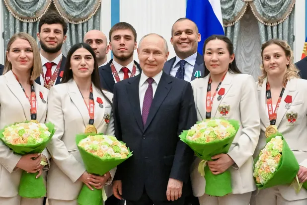 فلاديمير بوتين خلال استقباله لاعبين ولاعبات في بطولة الملاكمة (أ.ب)