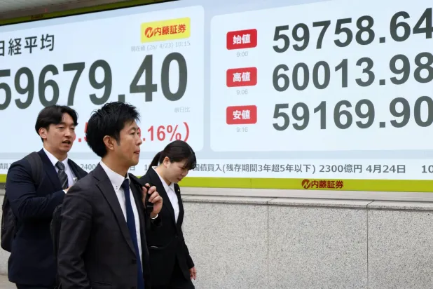 مشاة يمرون أمام شاشة تعرض حركة الأسهم في العاصمة اليابانية طوكيو (إ ب أ)