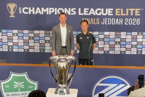 الياباني غو كورودا مدرب فريق ماتشيدا بجوار يايسله وكأس البطولة (الشرق الأوسط) 