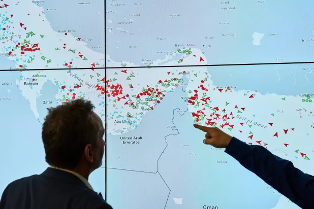 Hapag-Lloyd employees monitor the status of cargo ships in the Strait of Hormuz on a screen, in Hamburg, Germany, Wednesday, April 15, 2026. (AP Photo/Ebrahim Noroozi)