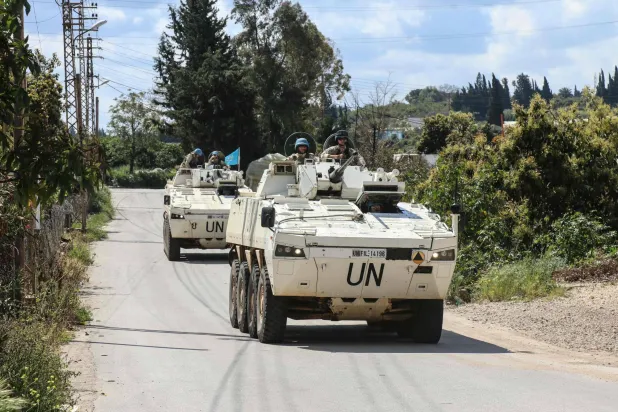 Members of the UN peacekeeping force in Lebanon (UNIFIL), in armored vehicles, patrol the road of the southern Lebanese village of Tair Debba on April 12, 2026. (Photo by Kawnat HAJU / AFP)
