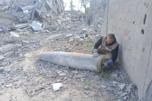 أحد عناصر هندسة المتفجرات التابعة لشرطة غزة يتعامل مع قذيفة غير منفجرة (الشرطة الفلسطينية)