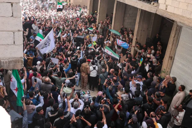 سوريون يحتفلون بالقبض على المتهم بارتكاب «مجزرة التضامن» في حي التضامن بدمشق الجمعة (إ.ب.أ)