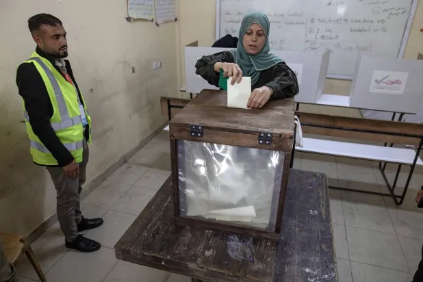 فلسطينية تدلي بصوتها داخل مركز اقتراع في دير البلح وسط قطاع غزة السبت (إ.ب.أ)