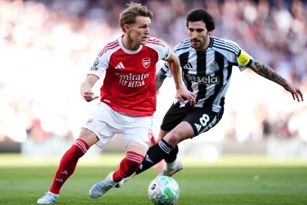 لاعب آرسنال مارتن أوديغارد يصارع على الكرة مع لاعب نيوكاسل يونايتد ساندرو تونالي (د.ب.أ)