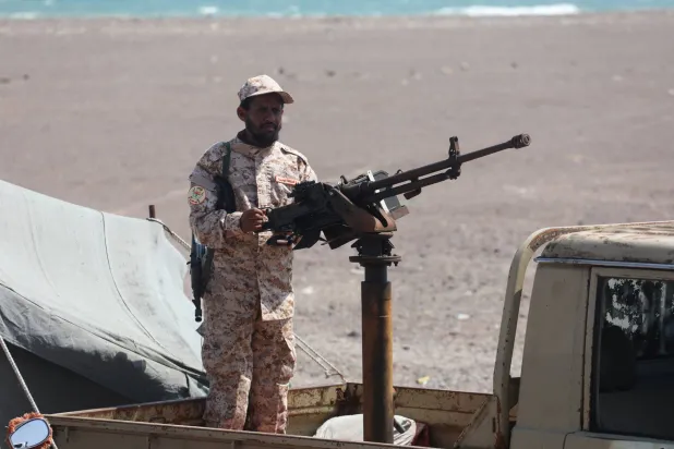جندي يمني يمسك رشاشاً على متن عربة عسكرية بالقرب من باب المندب (رويترز)