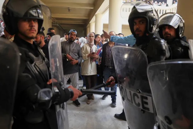 إغلاق شرطة مكافحة الشغب لقاعة المحكمة الجنائية في دمشق أمام الجمهور خلال الجلسة الأولى لمحاكمة عاطف نجيب الرئيس السابق لفرع الأمن السياسي في درعا (أ.ب)