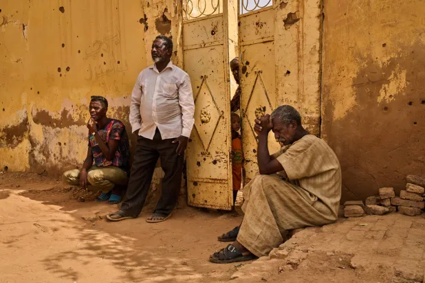 سودانيون ينتظرون استخراج رفات شقيقهم الذي قتلته «قوات الدعم السريع» في أم درمان (أ.ب) 