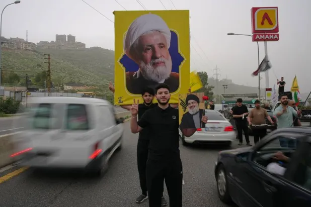  People hold up portraits of Hezbollah leader, Naim Qassem, top, and slain Hezbollah leader Hassan Nasrallah as displaced residents drive back to their villages, in Jiyyeh, near Sidon, southern Lebanon, Friday, April 17, 2026, following a ceasefire between Israel and Hezbollah. (AP) 