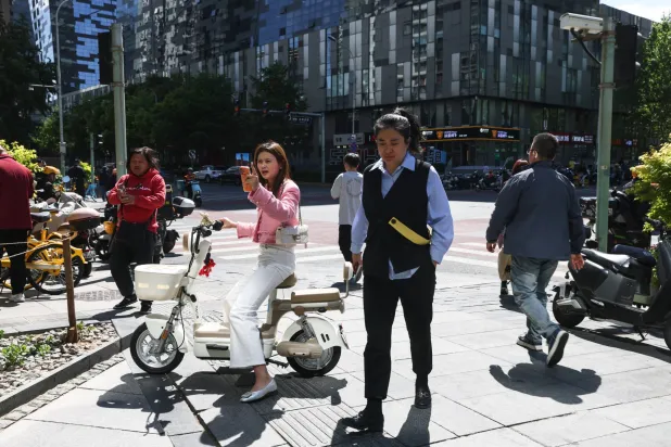 مشاة في الضاحية المالية بوسط العاصمة الصينية بكين (إ.ب.أ)