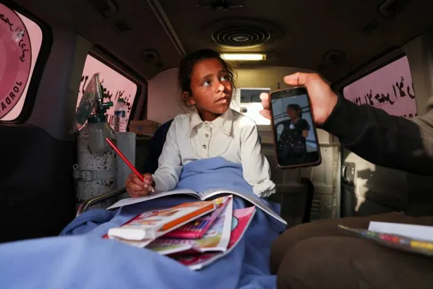 A wounded Palestinian girl, evacuated from Gaza for medical treatment, arrives in an ambulance at the King Hussein Bridge in Jordan, April 27, 2026. (Reuters)