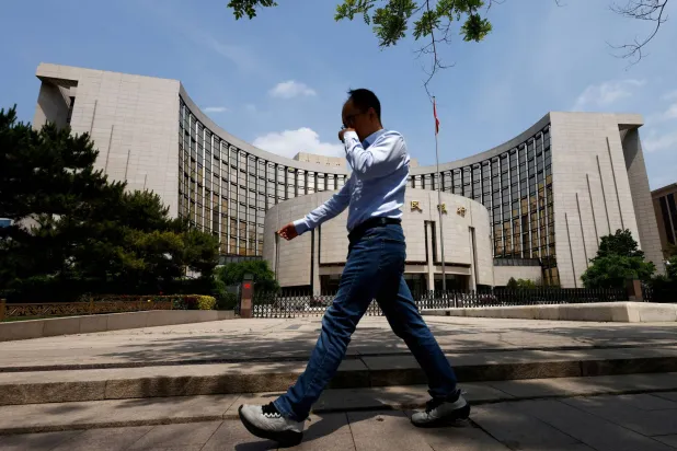 رجل يمر أمام مقر البنك المركزي في وسط العاصمة الصينية بكين (رويترز)