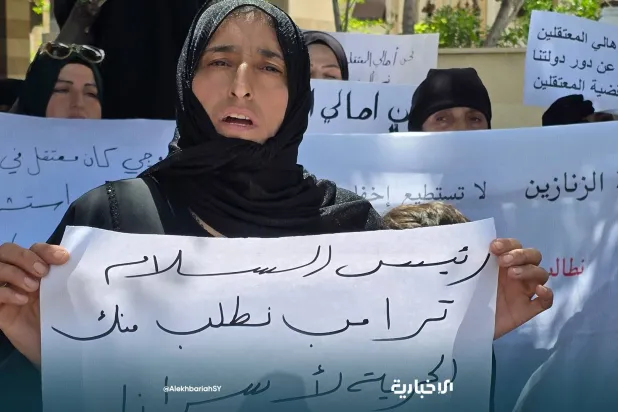 قريبة أحد الموقوفين في إسرائيل ترفع لافتة تطالب فيه الحكومة السورية بإعادته (الإخبارية)