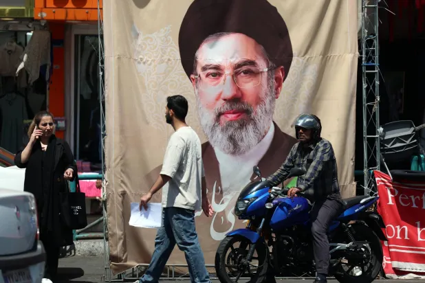 إيرانيون يمرون أمام ملصق للمرشد مجتبى خامنئي في طهران الثلاثاء (إ.ب.أ)