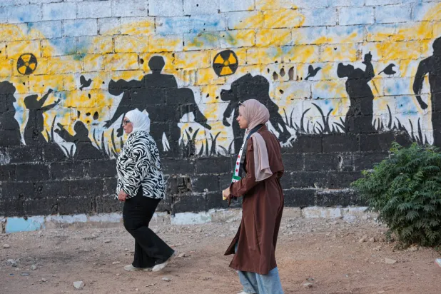 جدارية تُحيي ذكرى الهجوم الكيميائي عام 2013 في زملكا بضواحي دمشق مساء الخميس (إ.ب.أ)