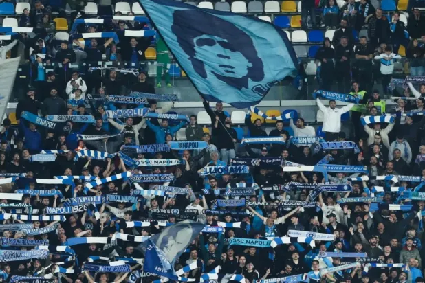 Napoli taraftarları, İtalya Ligi’nde oynanan bir maç sırasında Arjantinli efsane Diego Armando Maradona’nın fotoğrafının işlendiği bayrağı sallıyor. (AFP)