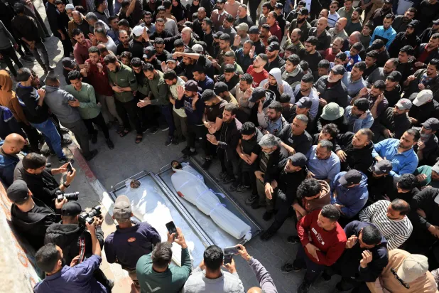 مشيّعون يحضرون جنازة فلسطينيين قُتلوا في غارة إسرائيلية وفق مُسعفين بمستشفى الشفاء بمدينة غزة (رويترز)