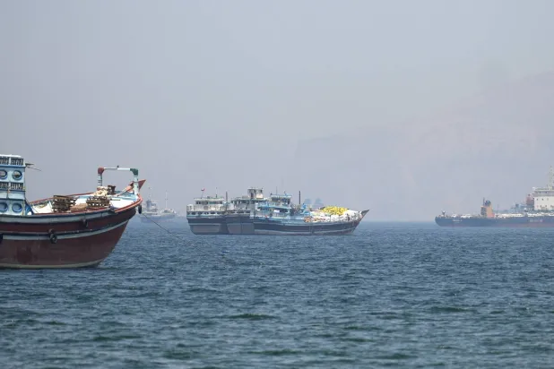 سفن وقوارب في مضيق هرمز قبالة شاطئ مسندم بعُمان الأربعاء (رويترز)
