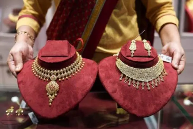 بائعة قلائد ذهبية داخل صالة عرض شركة «سينكو غولد آند دايموندز» للمجوهرات في كولكاتا بالهند (رويترز)