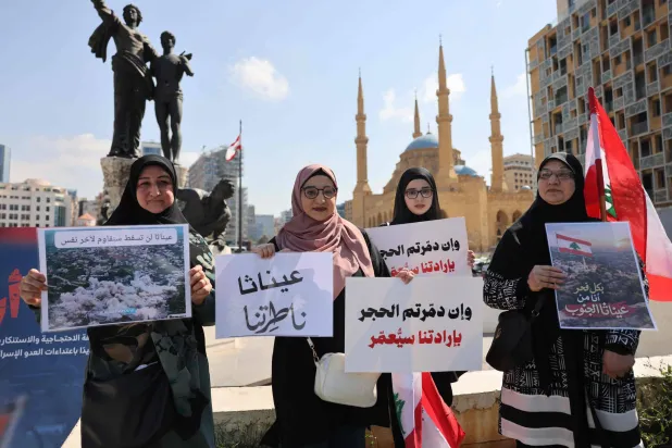 سكان من جنوب لبنان يحملون أسماء بلداتهم المحتلة والمعرضة للتدمير الإسرائيلي خلال اعتصام في ساحة الشهداء بوسط بيروت (أ.ف.ب)