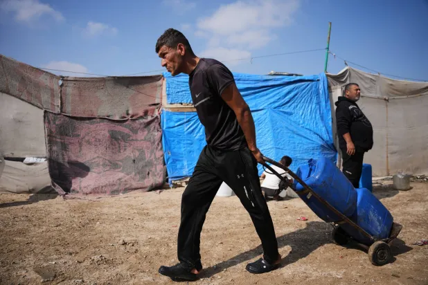  A Palestinian man carries jerrycans filled with water through a tent camp in Khan Younis, in the southern Gaza Strip, Thursday, April 30, 2026. (AP) 