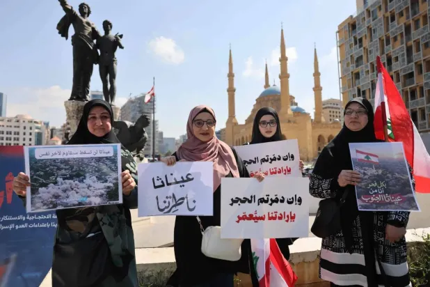 Residents from southern Lebanon hold signs bearing the names of their occupied towns and those at risk of Israeli destruction during a sit-in in Martyrs’ Square in central Beirut (AFP)