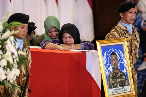 Family members of Indonesian soldier who was killed while serving with the United Nations Interim Force in Lebanon (UNIFIL) in southern Lebanon, mourn beside his coffin as the coffins of three Indonesian soldiers arrive at Soekarno-Hatta International Airport in Tangerang on April 4, 2026. (AFP) 