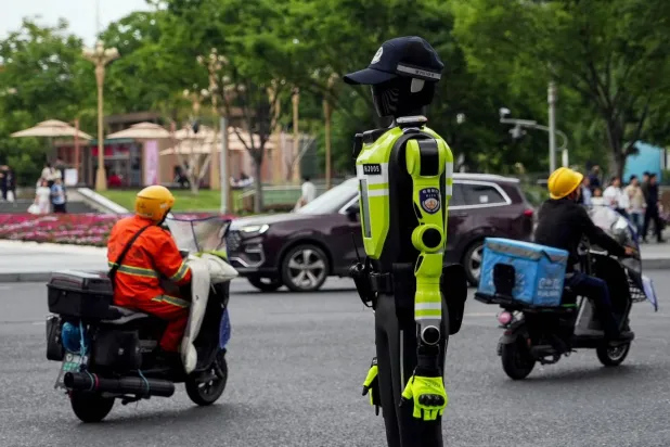  Hangzhou'da halk, polis memuru olan insansı robotun yanından geçiyor (AFP)