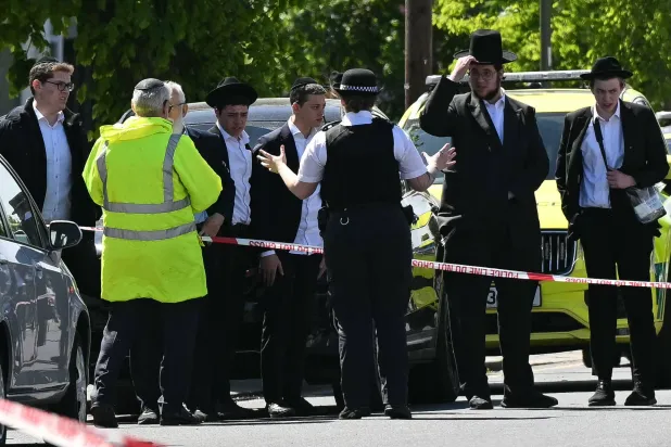 Local residents look on from outside a cordoned off area in the Golders Green neighbourhood of north London on April 29, 2026, following the stabbing to two people nearby. (Photo by JUSTIN TALLIS / AFP)