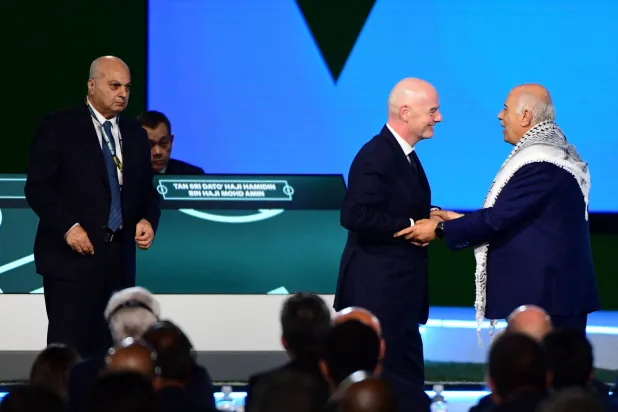 FIFA President Gianni Infantino (C) interacts with the President of the Palestine Football Association Jibril Rajoub as the Vice-President of Israel Football Association Basim Sheikh Suliman (L) looks on during a heated moment in the 76th FIFA Congress in Vancouver, Canada on April 30, 2026. (Photo by Don MacKinnon / AFP)