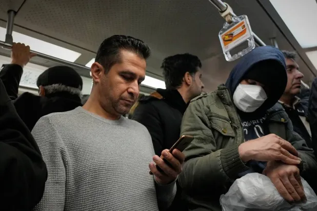 A man uses his smartphone while riding the subway in Tehran, Iran, Tuesday, Dec. 24, 2024. (AP)