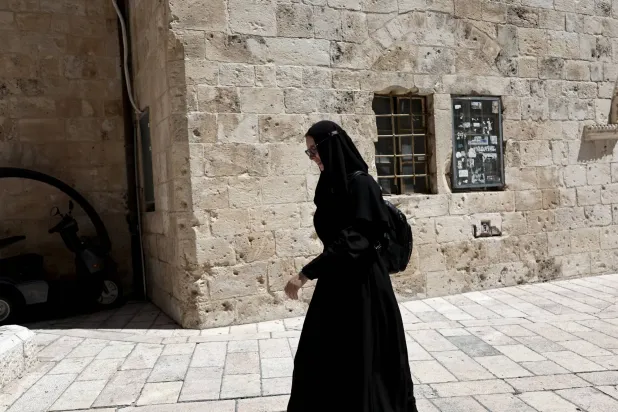راهبة تمر بالقرب من البلدة القديمة في القدس (إ.ب.أ)