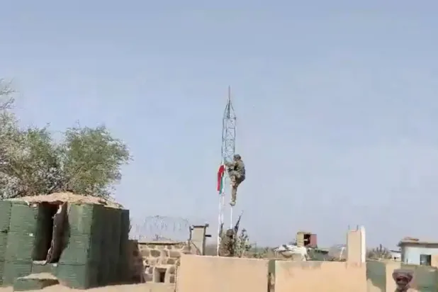 Dün Mali'nin Tessalit kentindeki askeri üste bir isyancı bayrak direğine tırmanarak bayrağı indirdi (Reuters)