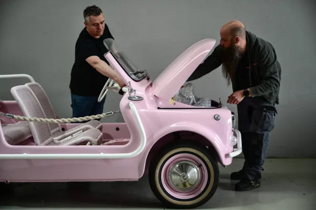 Owner of the Officine Gentile garage, Giovanni Gentile (L) and a worker inspect a finished model of the Fiat 500 Jolly Lido at the Officine Gentile garage in Turin on April 30, 2026. (AFP) 