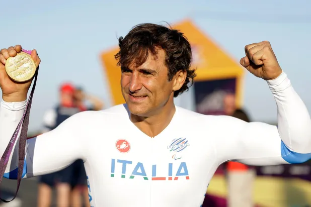 Alex Zanardi of Italy celebrates holding his gold medal following the medal ceremony for the man's road cycle individual time trial H4 category at the 2012 Paralympics games, Wednesday, Sept. 5, 2012, at Brands Hatch motor racing circuit near London. (AP)