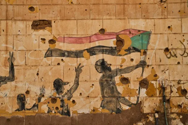  A painting depicting people holding the Sudanese flag is seen on a wall damaged by bullets and shrapnel in Omdurman, on the outskirts of Khartoum, Sudan, Thursday, April 23, 2026. (AP) 