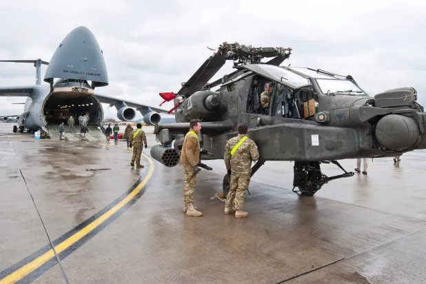 An AH-64 Apache attack helicopter stands in front of a Galaxy C-5 transport plane at the US Air Base in Ramstein, western Germany, on February 22, 2017. (dpa/AFP)
