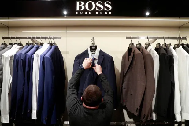 An employee displays suits at the Hugo Boss section of the Central Universal Department Store (TsUM), in Kyiv, Ukraine January 25, 2021. (Reuters)
